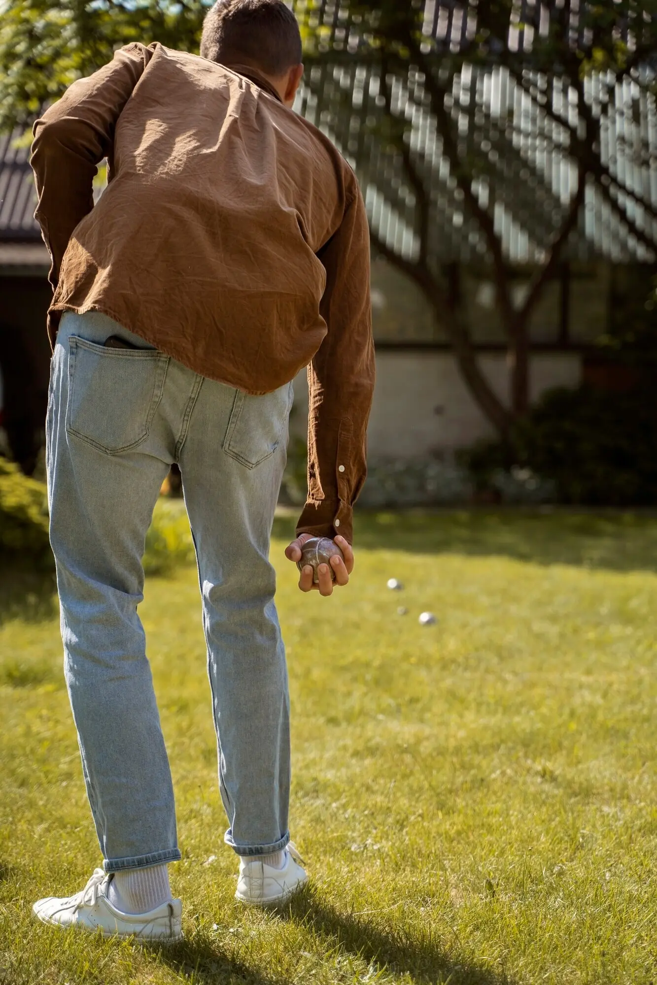 Rear view of a man playing petanque.